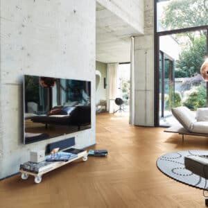 Fiskebensgulv i lys eik med ultramatt finish. 140 mm brede bord, slitesterkt herdet kjerne og vannresistent overflate – perfekt for nordisk interiør.