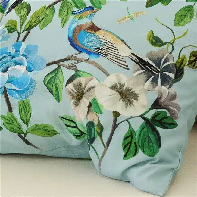 Stor pyntepute fra Designers Guild med blomster og fugler brodert på bomullscanvas i dyp cobaltblå tone.