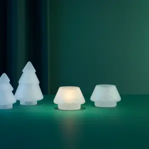 To frostede hvite lyslykter fra Hadeland Glassverk med mykt lys, stående på grønt bord mot mørk bakgrunn.