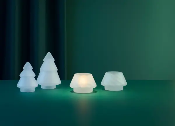 To frostede hvite lyslykter fra Hadeland Glassverk med mykt lys, stående på grønt bord mot mørk bakgrunn.