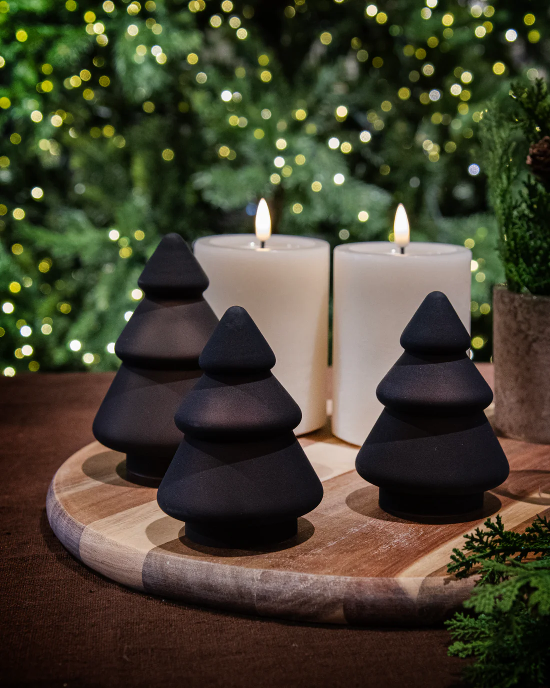 Tre frostede kakaofargede glasstrær fra Hadeland Glassverk plassert på grønn bakgrunn i stemningsfull belysning.