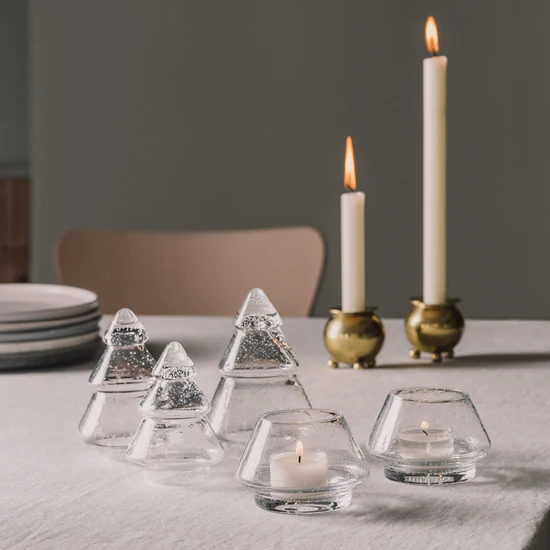 Stemningsfullt miljøbilde med Gran lyslykter i klart glass og glasstrær fra Hadeland Glassverk på dekket bord.