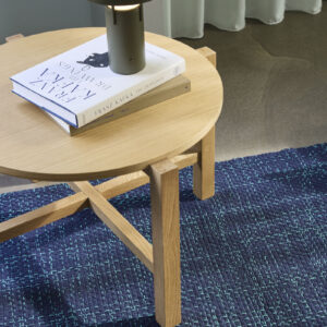 BringMe oppladbar og dimbar bordlampe Mini i Metallic Dark Green fra Hübsch plassert på et rundt trebord, med varmt tent lys.