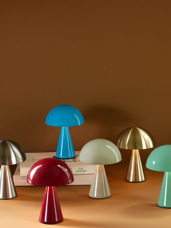 Mush oppladbar og dimbar bordlampe i Nickel fra Hübsch vist sammen med andre fargevarianter, med mykt tent stemningslys.