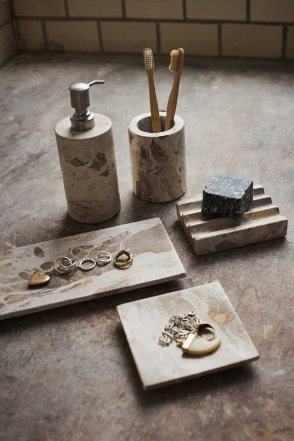 Muubs Vita tannbørsteholder i marmor Seashell på baderom sammen med såpedispenser og tilbehør i naturlig stein