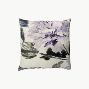 Designers Guild pyntepute med stort lilla blomsterdesign på lys bakgrunn og ensfarget rosa bakside 40x40