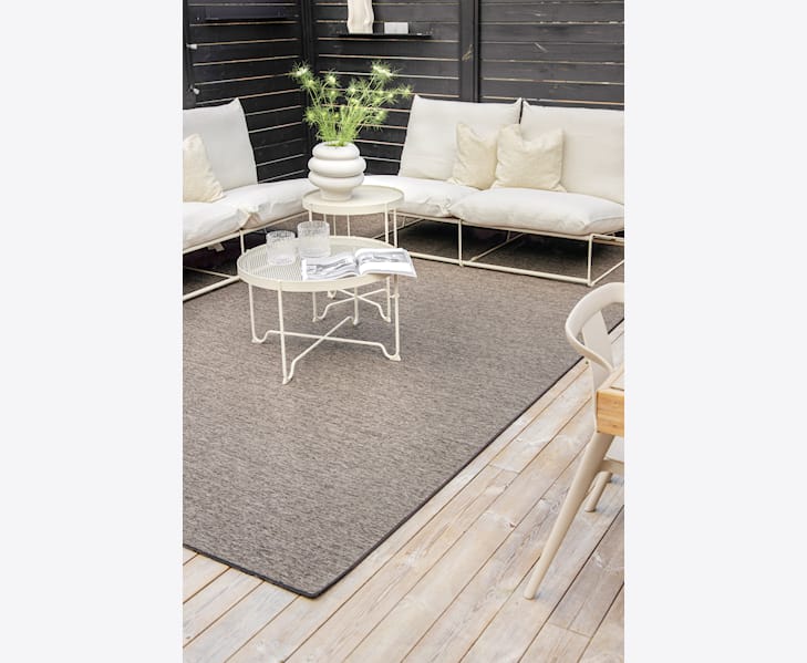 Måltilpasset terrasseteppe brun i natur på en terrasse med møbler