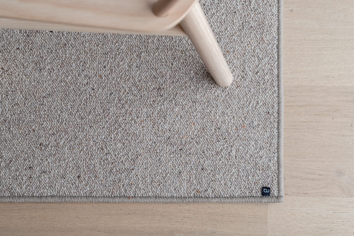 Langett kanting gir teppet en slitesterk og elegant avslutning. Langett er en kant i form av garn som er sydd ca. 1 cm bredt rundt kanten av teppet, og tilpasses teppets farge for et harmonisk og gjennomført uttrykk.