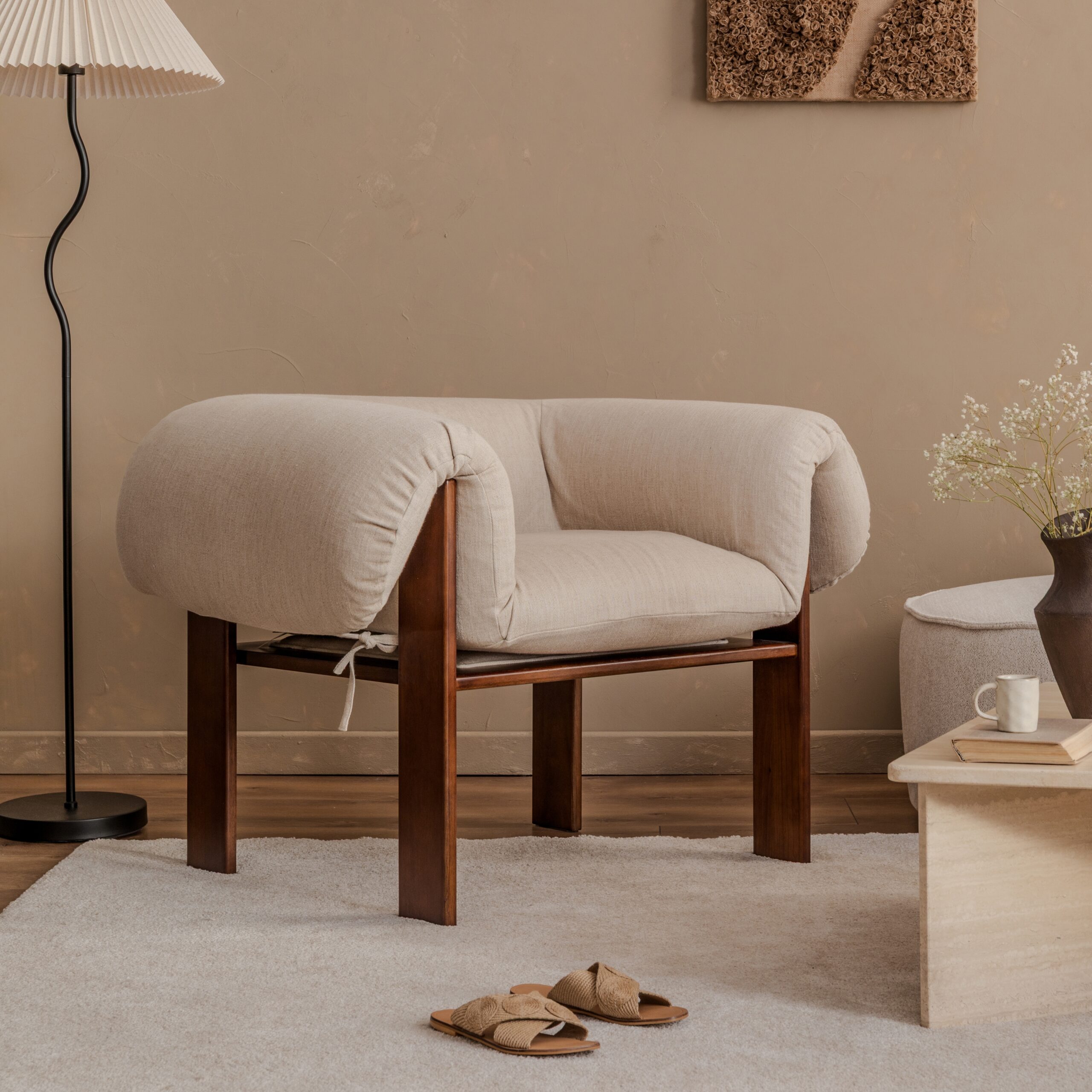 Stue med stol, teppe og tekstiler i varme toner som skaper lag-på-lag tekstur