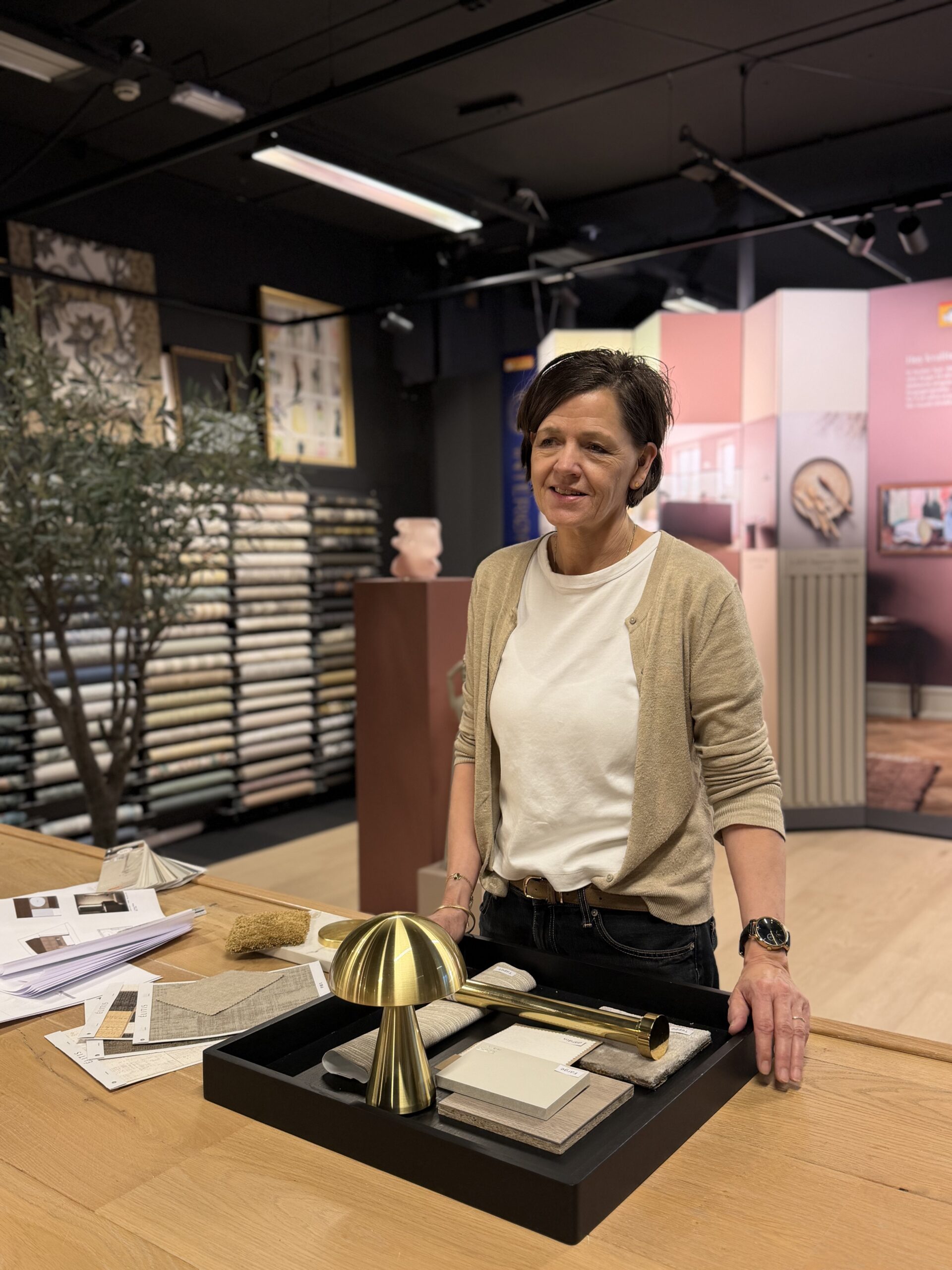 Interiørkonsulent fra Interiørfaghuset T. Lund ved et bord med moodboard og prøver i showroomet i Stavanger